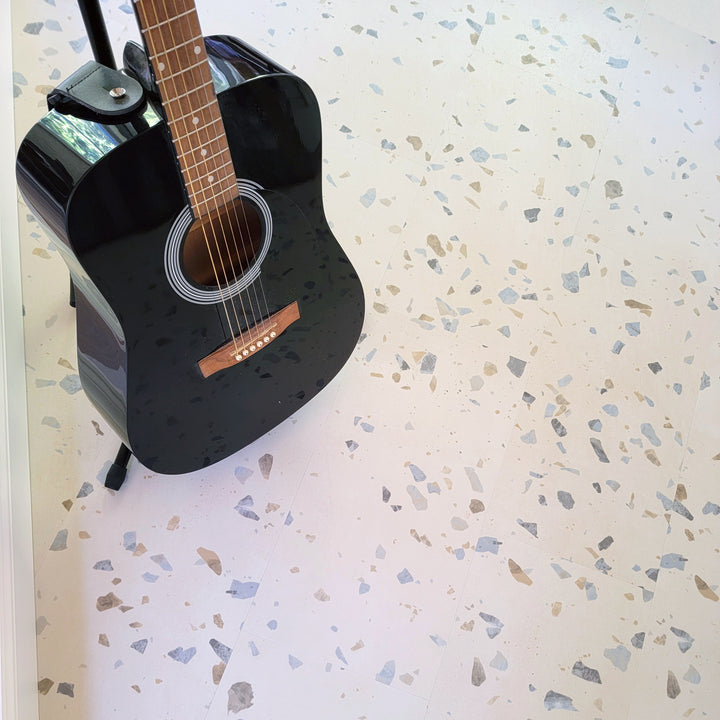 Allure vinyl terrazzo flooring installed with black guitar