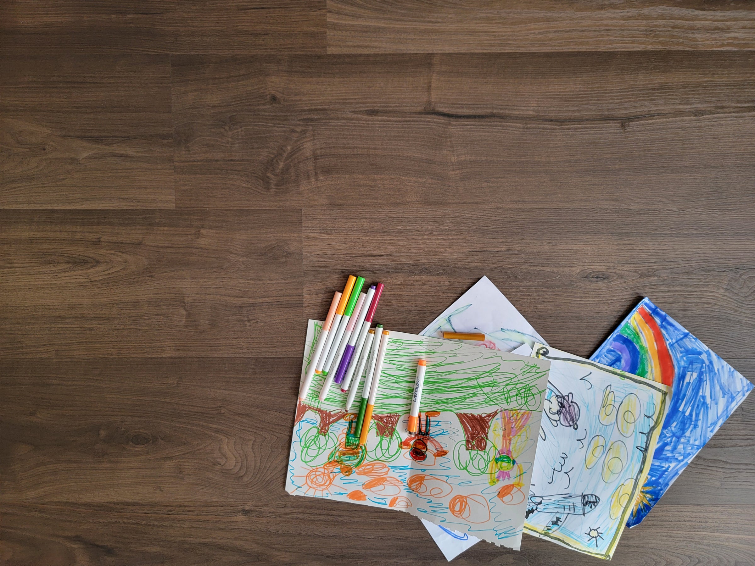 Dark Brown Vinyl Plank Flooring with Kids Artwork and Markers