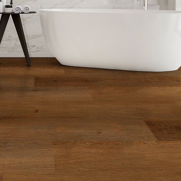 Allure Caramel Cookie plank flooring in a bathroom with a bathtub and side table with towels