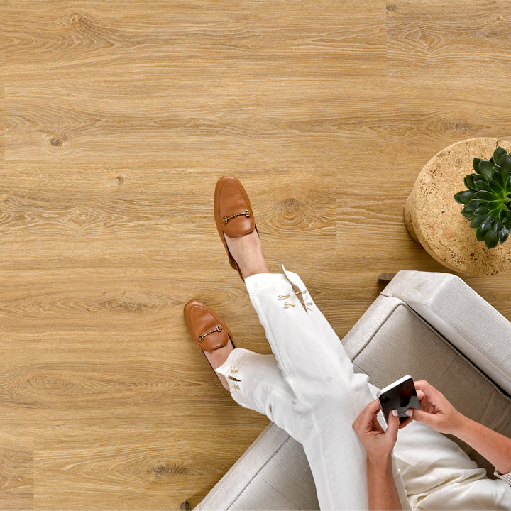 Allure SRP TPU Flooring in Contemporary Oak Cappuccino installed floor view from above with person sitting in chair