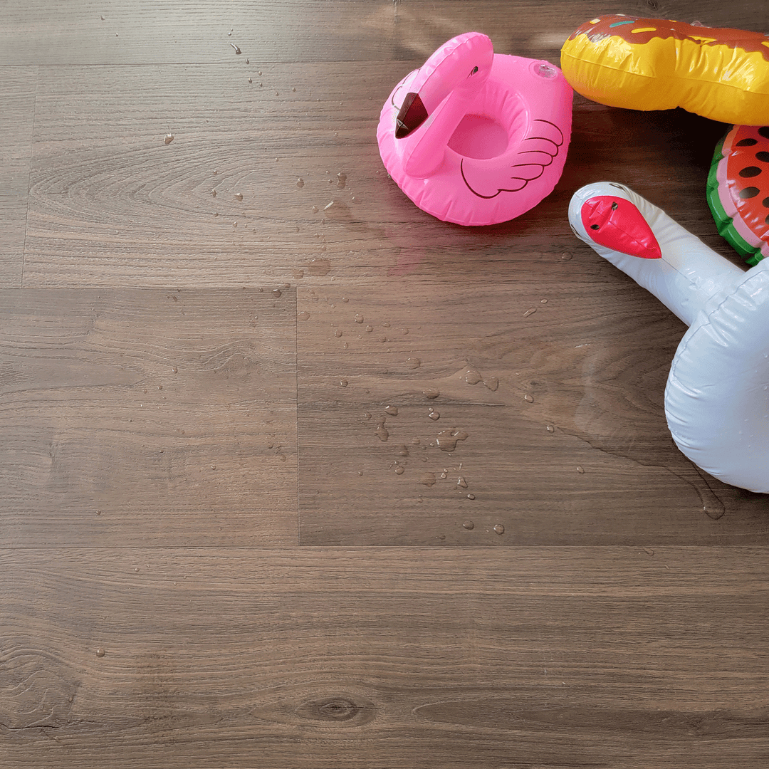 Dark brown vinyl flooring with pool toys and water on the floor